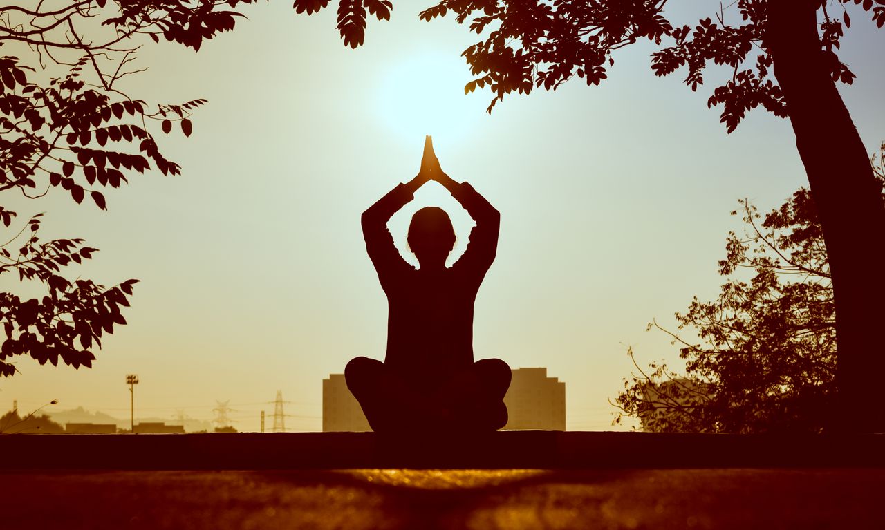 about-img Silhouette of a person practicing yoga outdoors during sunrise, creating a calming atmosphere.